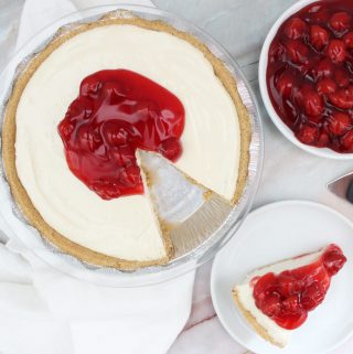 Cherry Cream Cheese Pie, one slide on a white plate, with cherry pie filling in a bowl on the side.