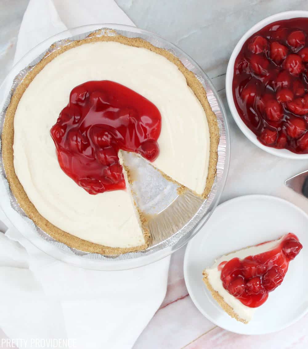 Cherry Cream Cheese Pie, one slide on a white plate, with cherry pie filling in a bowl on the side.