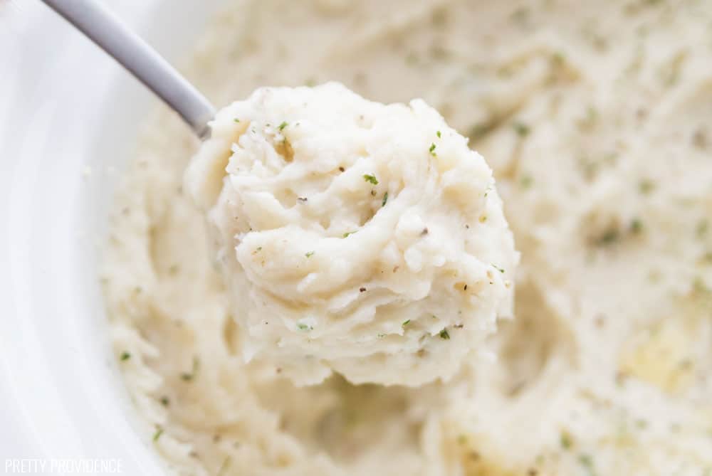 Slow Cooker Mashed Potatoes close up on a spoon with salt and pepper.