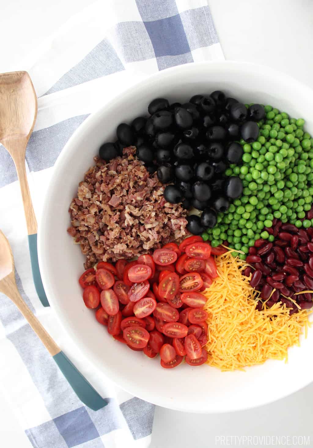 Bowtie pasta salad with tomatoes, cheese, bacon bits, kidney beans, peas and olives! To die for good! 