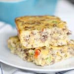 Breakfast casserole with sausage, eggs, cheese and bell peppers on a white plate