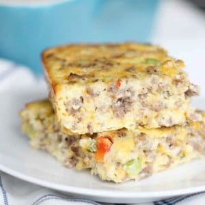 Breakfast casserole with sausage, eggs, cheese and bell peppers on a white plate