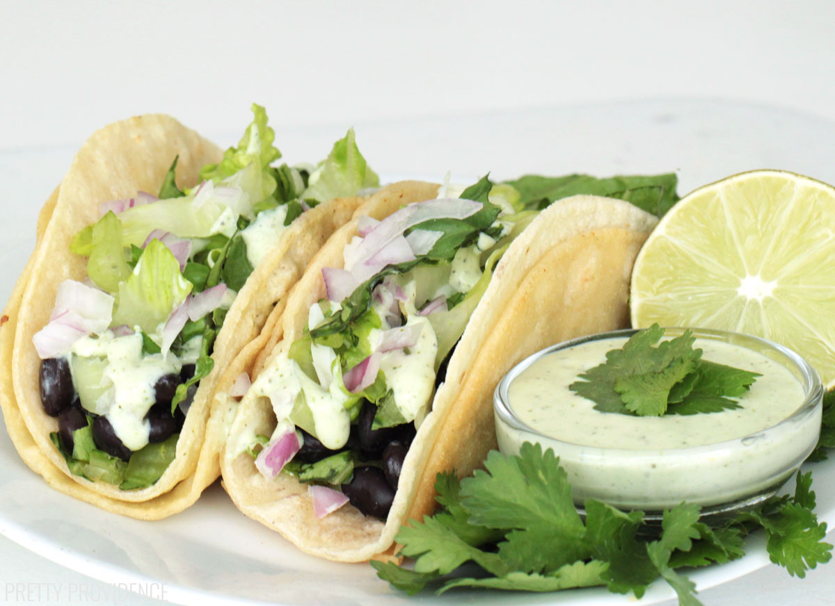 Black bean tacos with jalapeño ranch, lettuce, cheese and red onion