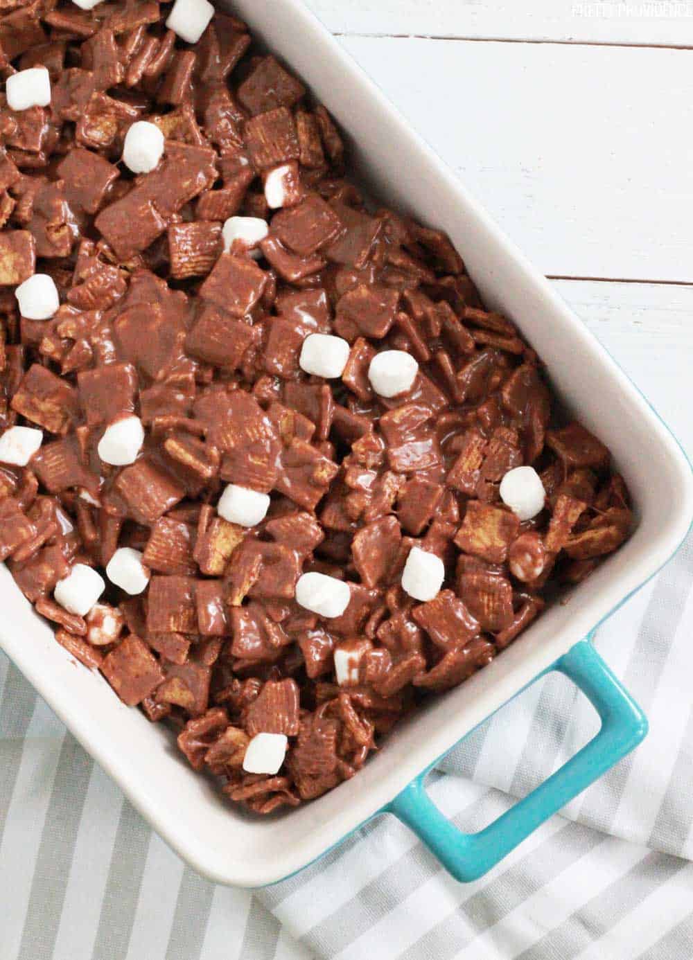 Golden grahams s'mores with marshmallows in a 9x13 ceramic pan.