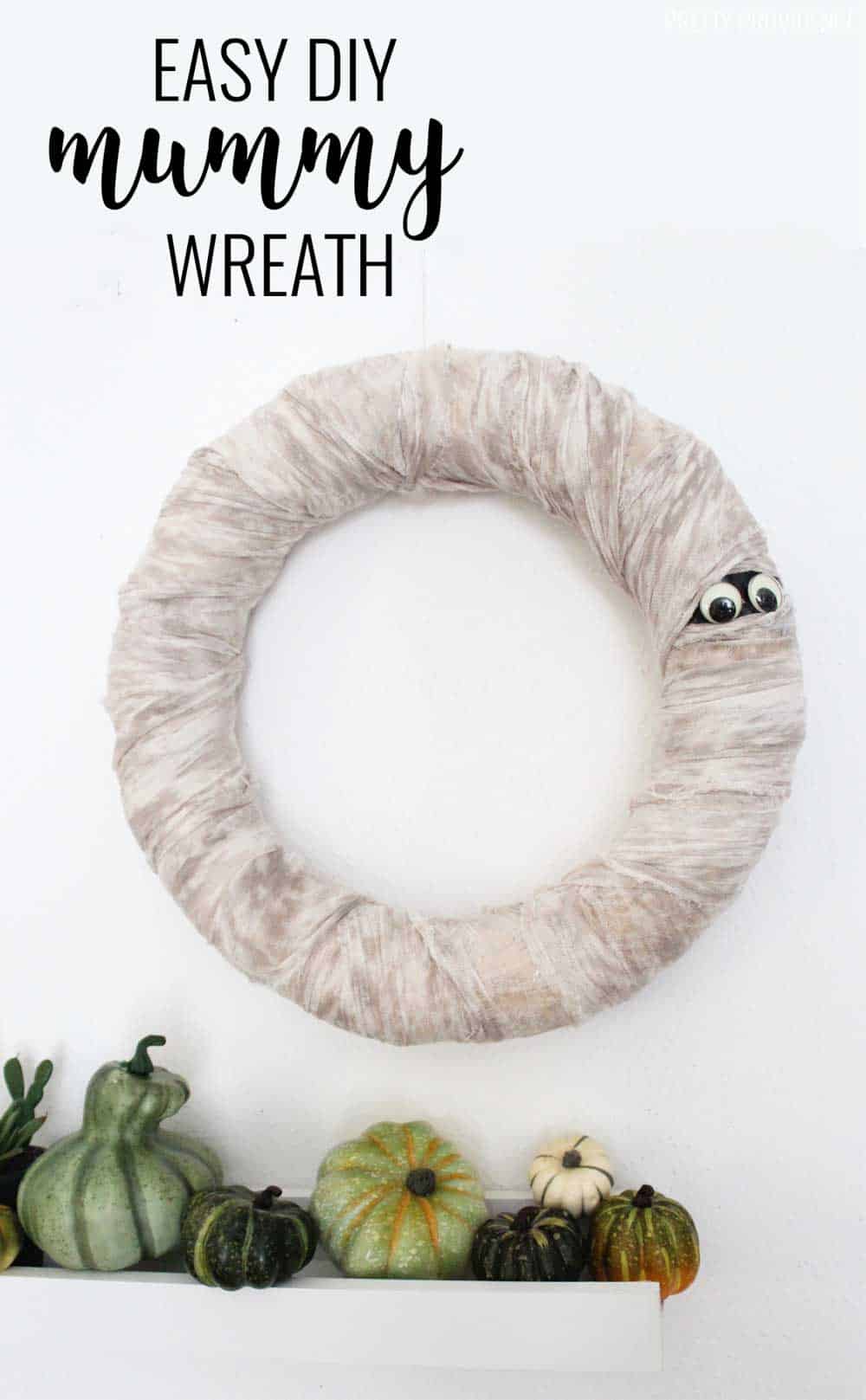 Halloween Wreath that looks like a mummy - wreath wrapped in cheese cloth with googly eyes peeking out.