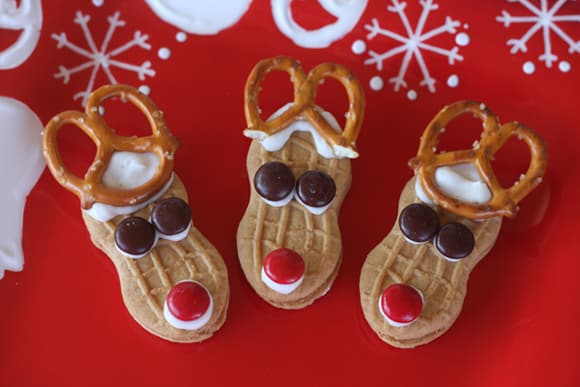 Reindeer Nutter Butter cookies decorated with red noses and pretzel antlers