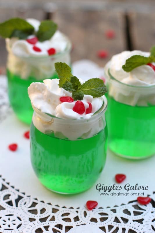 Green Jello topped with whipped cream, red candies and mint leaves - Misteletoe Jello!