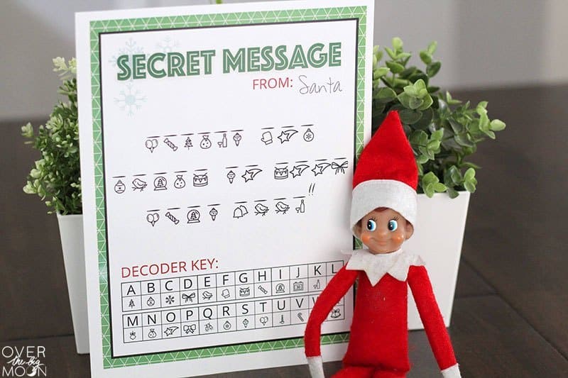 Secret Message from Santa with decoder key on white paper with a green border and Elf on the Shelf next to it.