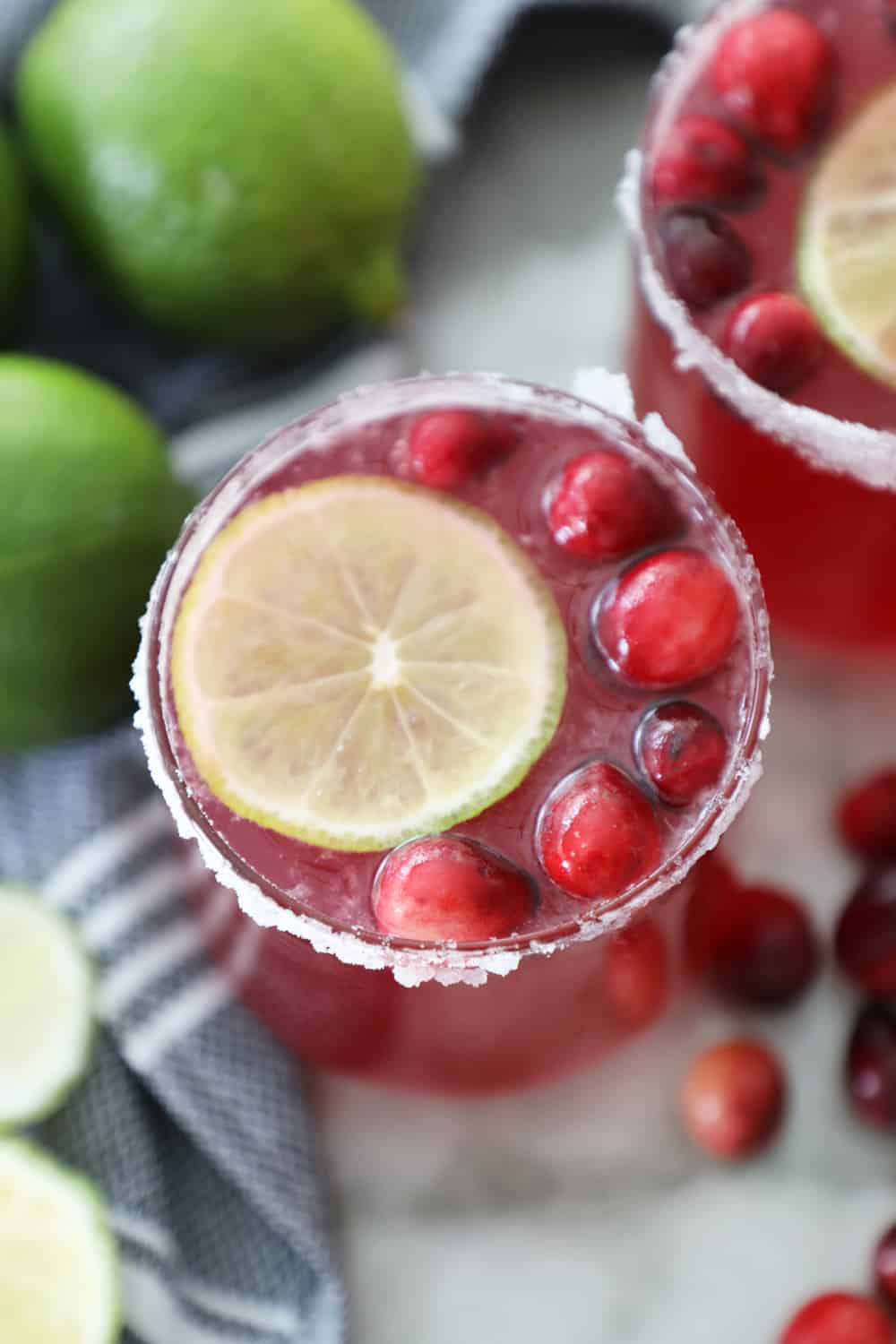 cranberry punch in a sugared glass with a lime slice and fresh cranberries