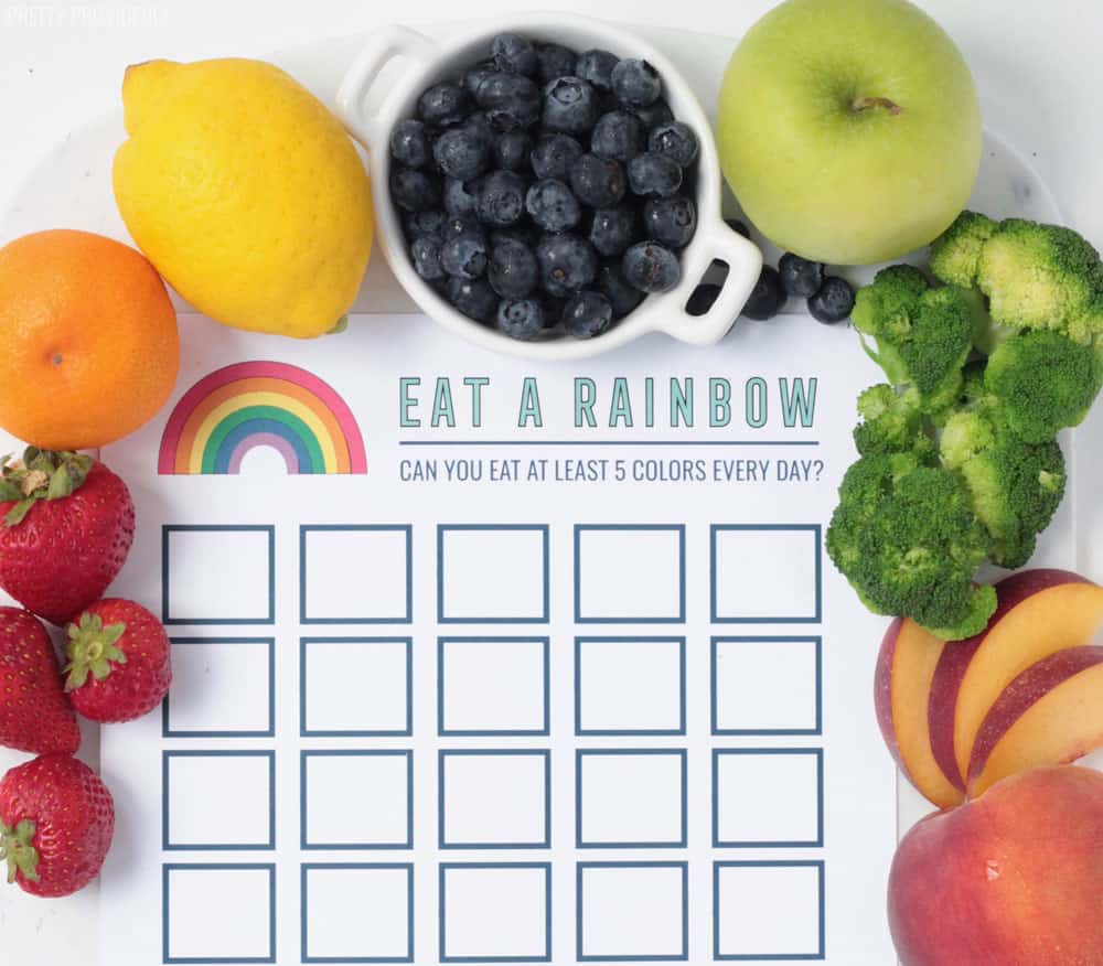 Reward chart printable for eating healthy - 'Eat A Rainbow' with fresh fruit and vegetables surrounding the paper.