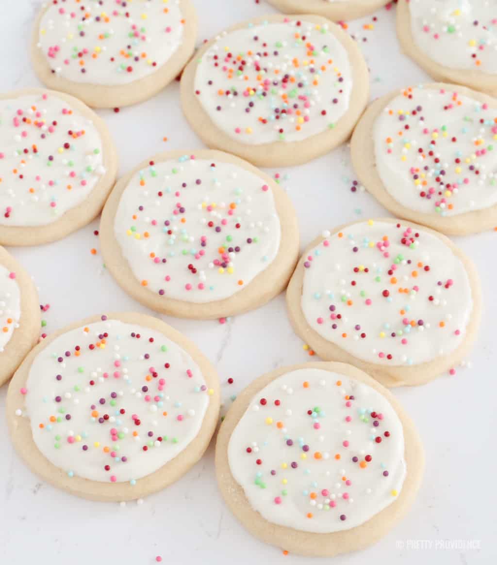 Homemade sugar cookies with white cream cheese frosting and sprinkles