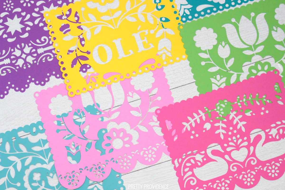 Papel Picado banner sheets made from colorful card stock with Cricut on a white shiplap surface