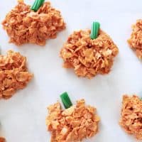 cornflake pumpkins with green licorice stems on a white marble countertop