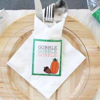 Free Thanksgiving Printable utensil holder, white card stock with a green border with words 'Gobble, Gobble, Gobble' on it.