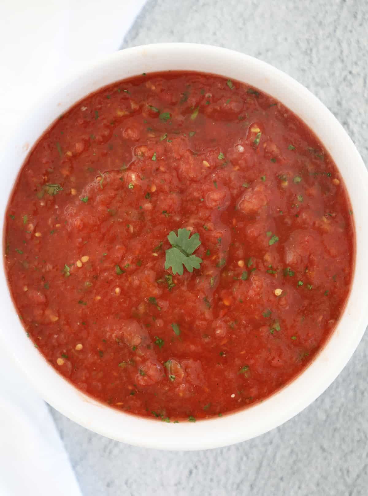 A small white bowl full of easy homemade salsa. 