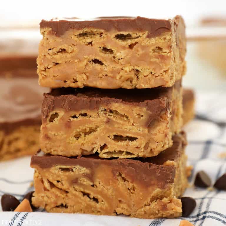 Three Chex Scotcheroos bars stacked up on a tea towel.