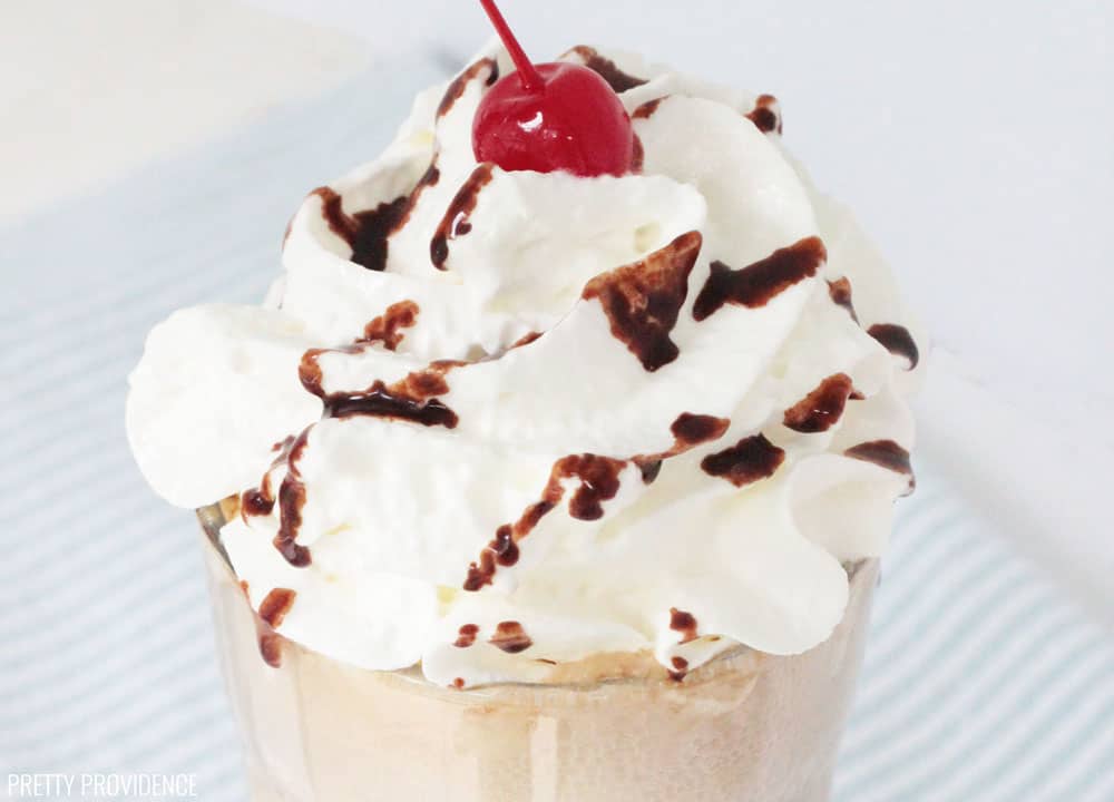 Root Beer Float topped with whipped cream, cherry and drizzled with chocolate syrup.