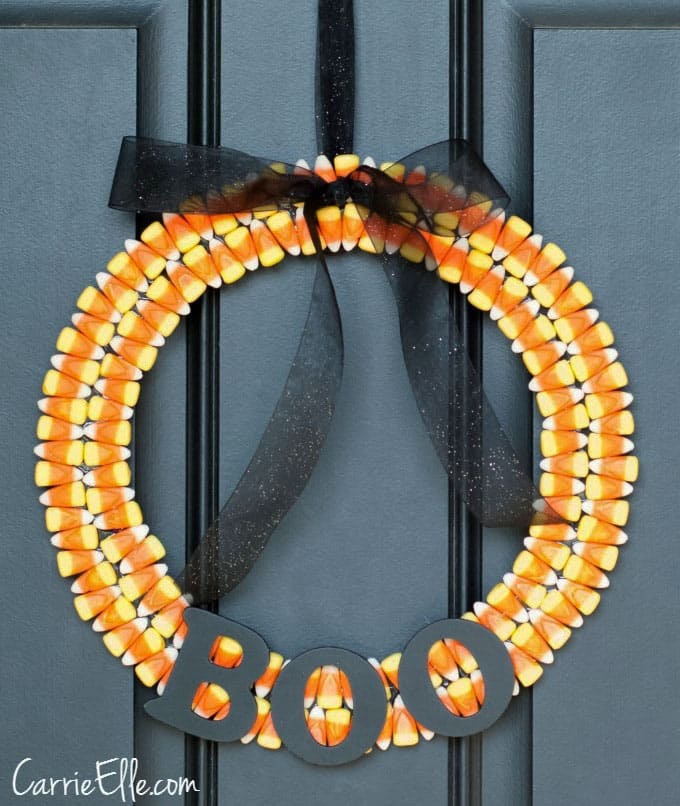 Candy corn wreath on a black front door.