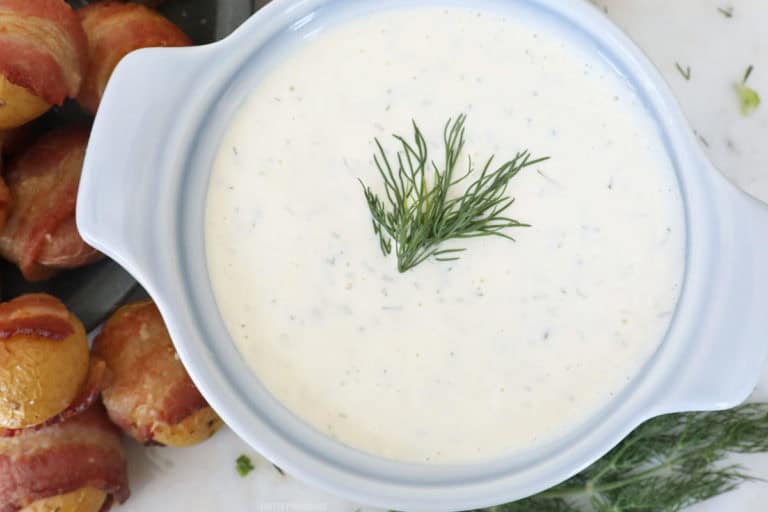 Bacon-Wrapped Potatoes surrounding a small bowl of creamy dill sauce.