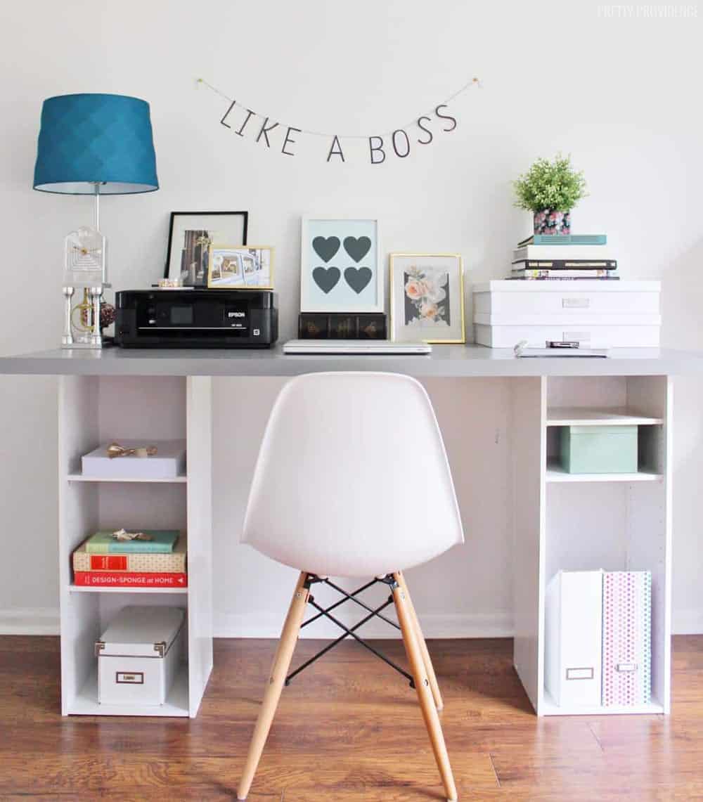 gray desk top with white bookshelves for legs, modern chair and banner that says 'like a boss'