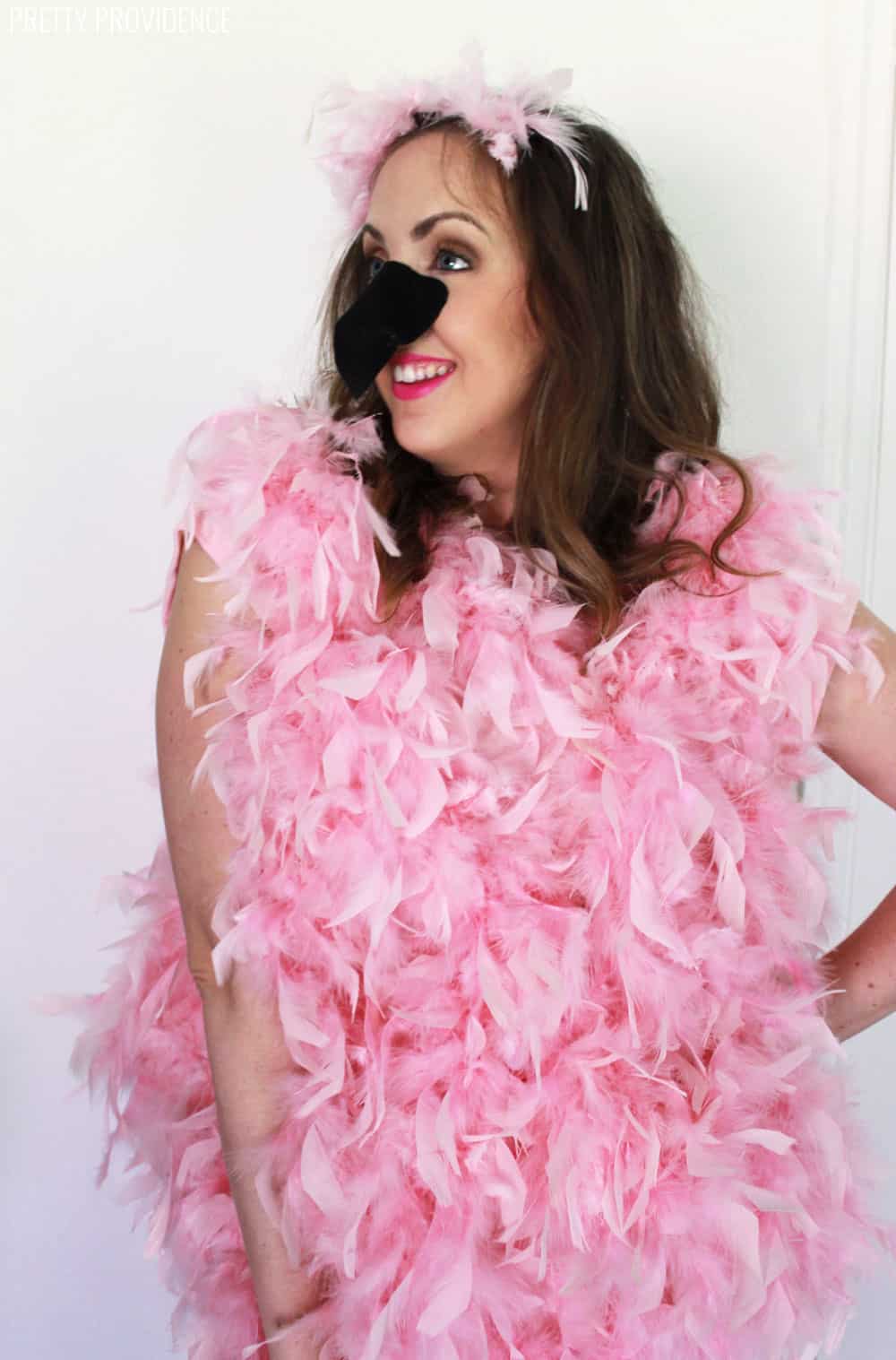 Woman in a pink flamingo costume, pink feather boas on a pink t-shirt with a black felt beak.