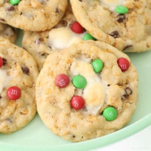 Cookies with red and green mini m&m's, cornflakes and melted marshmallow on a green plate