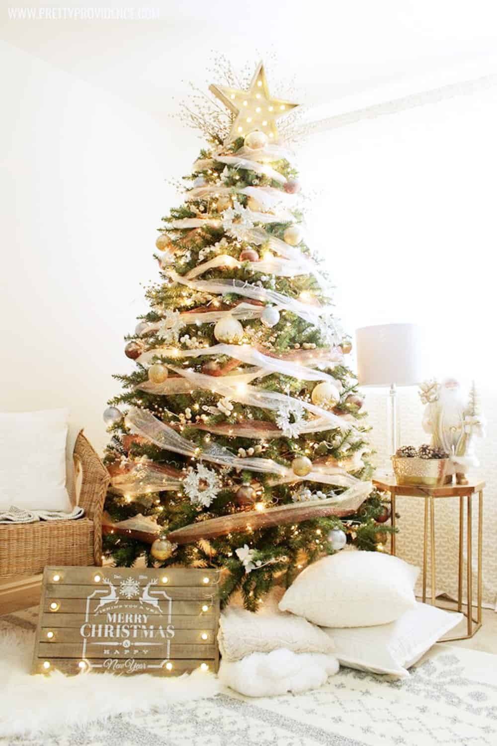 dream christmas tree decorated using bronze, silver, and gold surrounded by pillows and decor