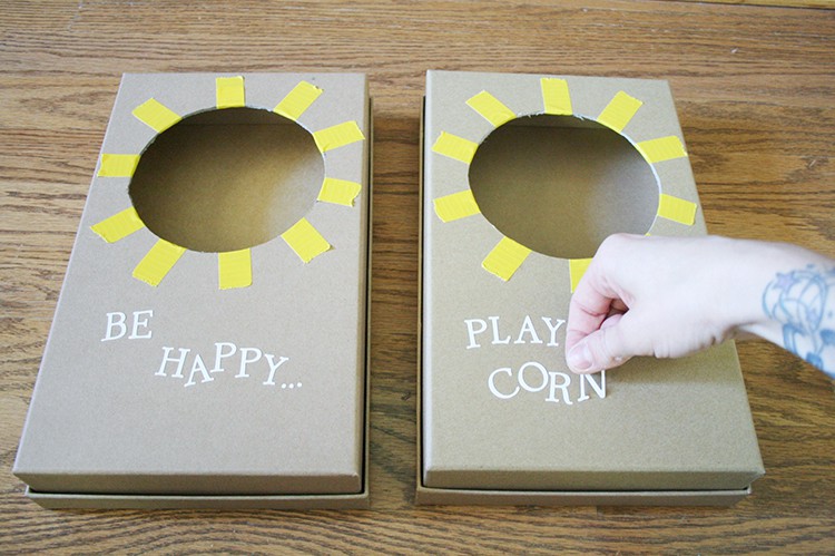 Two mini cornhole boarsd decorated with stickers.