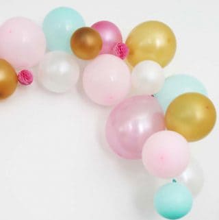Balloon Garland with Pink, Blue, Gold and White Balloons against a white wall.