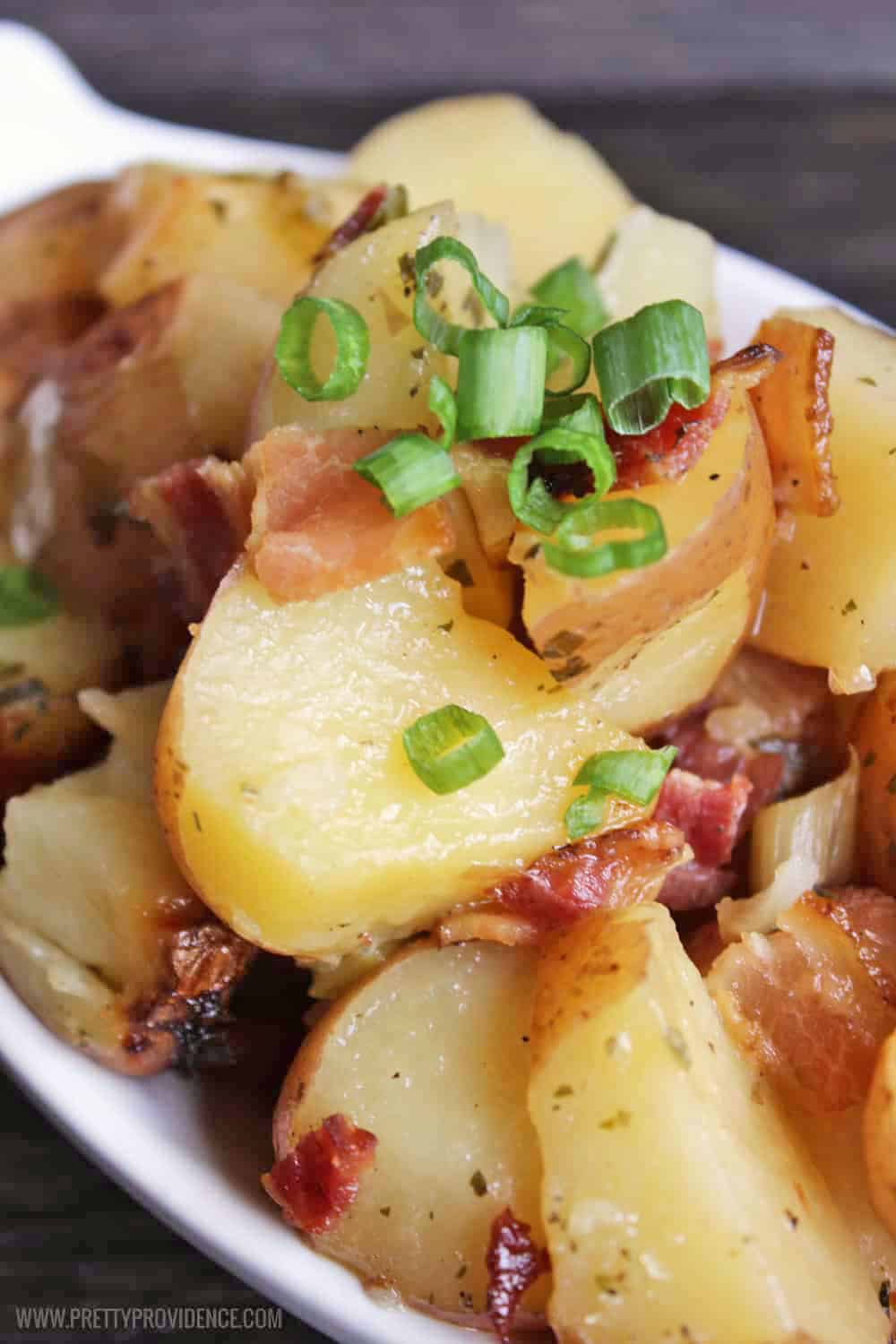 Slow Cooker ranch potatoes with green onions and bacon on top. Close up.
