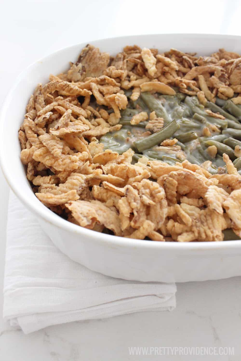 Green Bean Casserole with fried onions on top in a white dish.