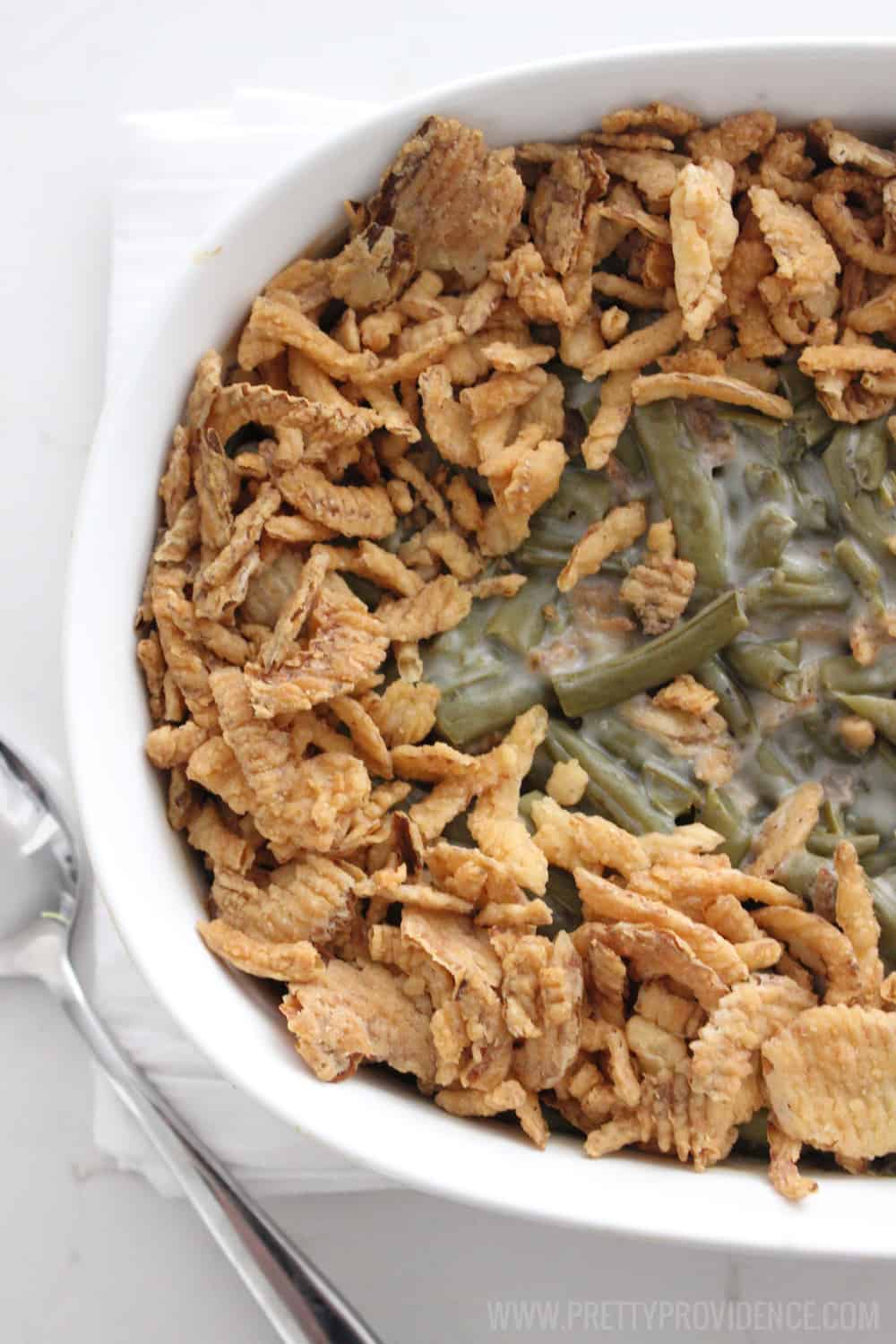 Green Bean Casserole in a white casserole dish overhead with fried onions on top.