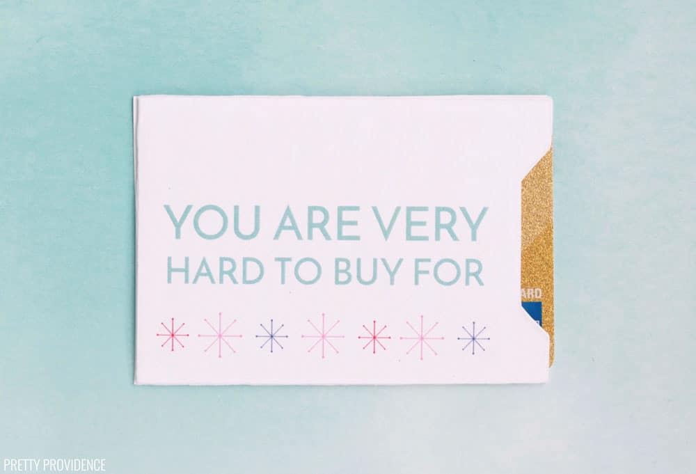 White gift card envelope with 'You Are Very Hard to Buy For" in blue text with snowflakes on a blue background.