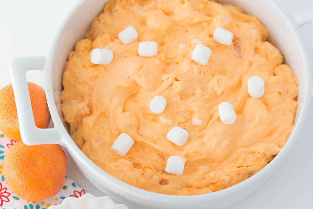 orange fluff in a white pot next to oranges