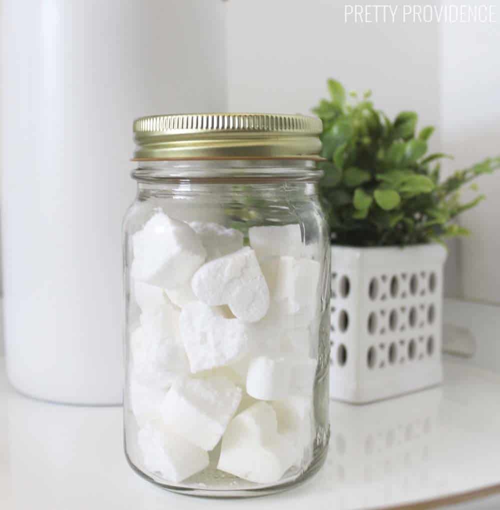 a mason jar of heart shaped toilet cleaner bombs on a bathroom counter