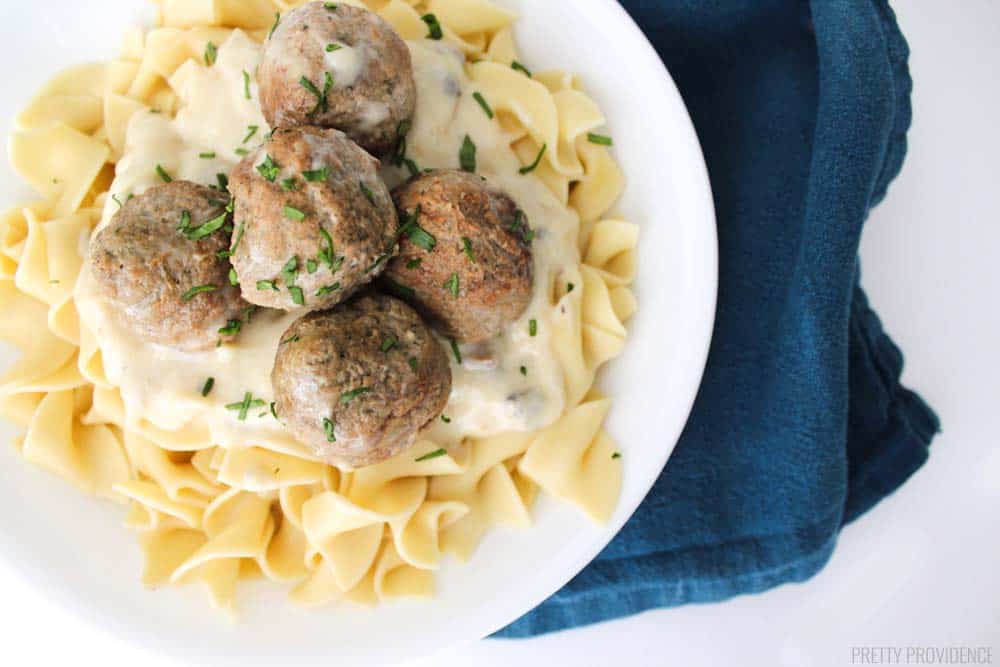 A small bowl of noodles with crockpot meatball stroganoff on top. 