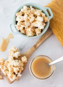 homemade caramel next to a bowl and a spoon filled with caramel popcorn
