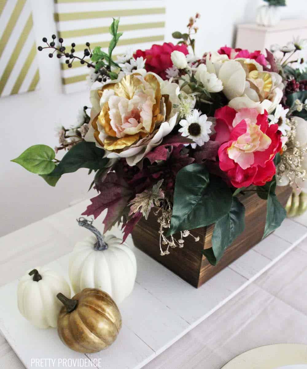 Fall floral arrangement centerpiece, with gold and cream peonies, pink, white flowers and gold berries.