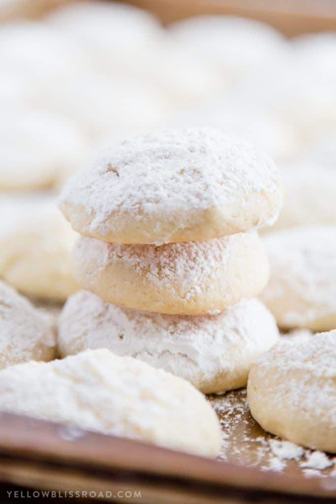 Cheesecake cookies dusted with powdered sugar on a cookie sheet