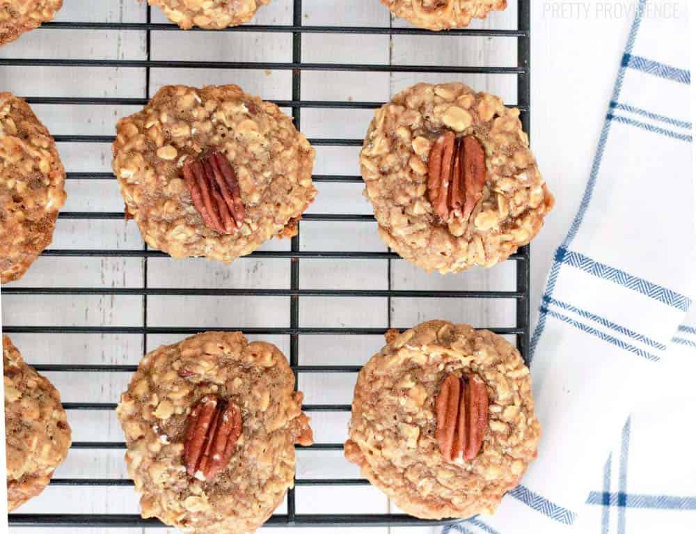 Maple Pecan Oatmeal Cookies with a pecan in the middle of each one, cooling on a cooling rack 