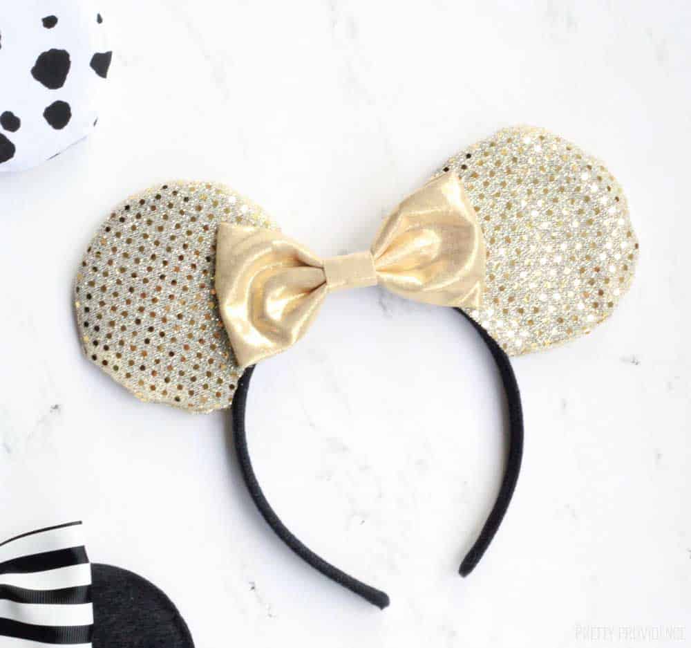 gold minnie mouse ears with a gold bow on a white countertop