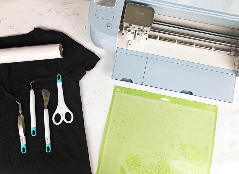 black t-shirt, cricut machine, and supplies to make a diy halloween shirt