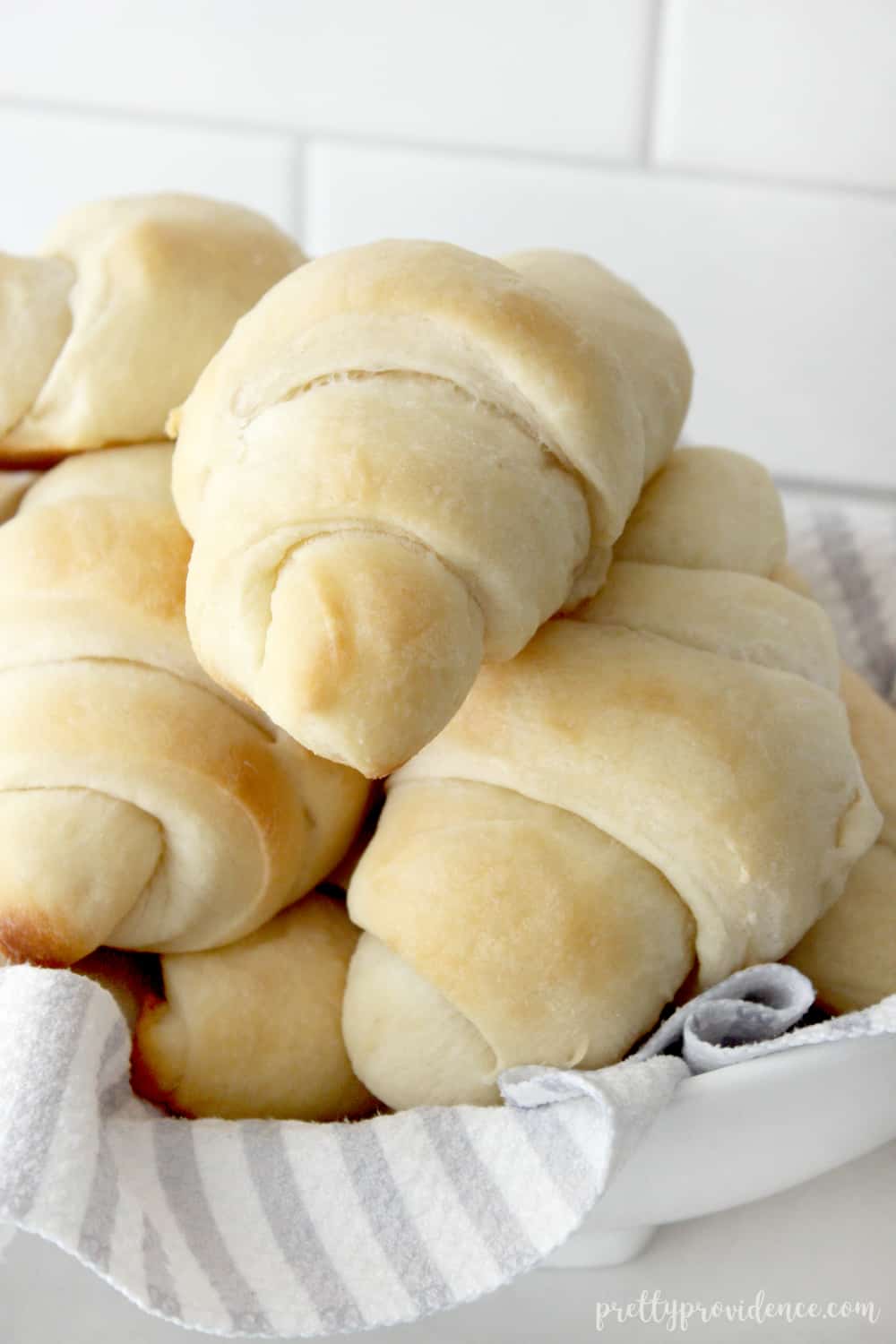 homemade dinner rolls stacked high in a basket