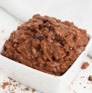 Chocolate rice pudding topped with mini chocolate chips in a small white square dish.