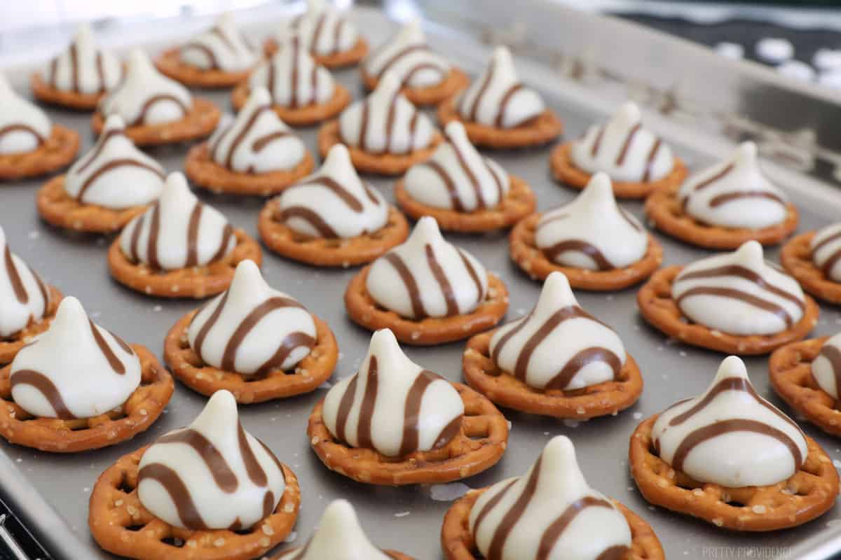 monster pretzel hugs lined up on a parchment covered cookie sheet