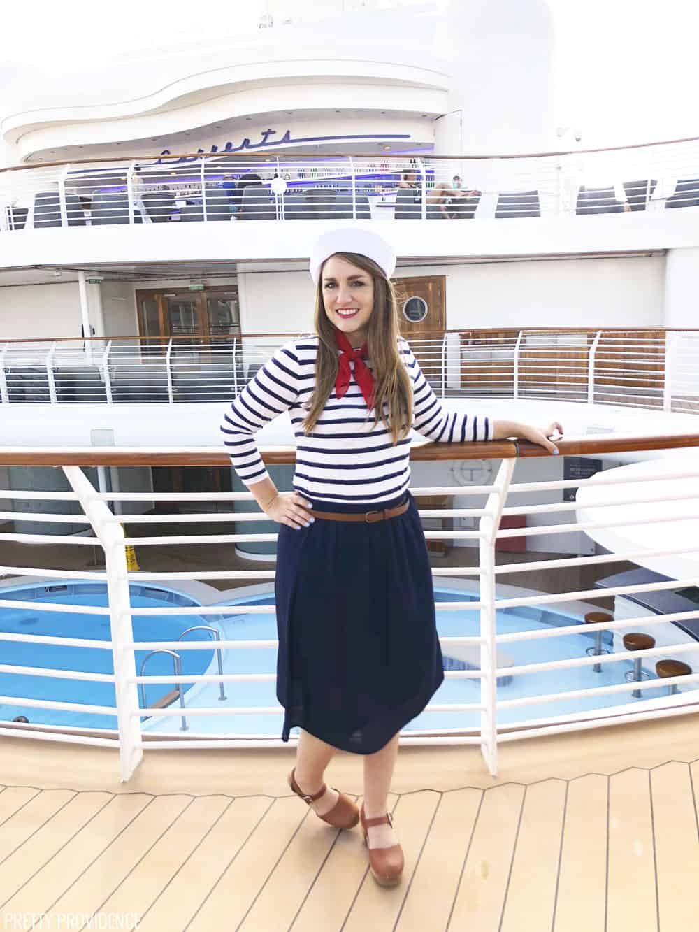 a girl on the deck of a ship posing in a sailor costume