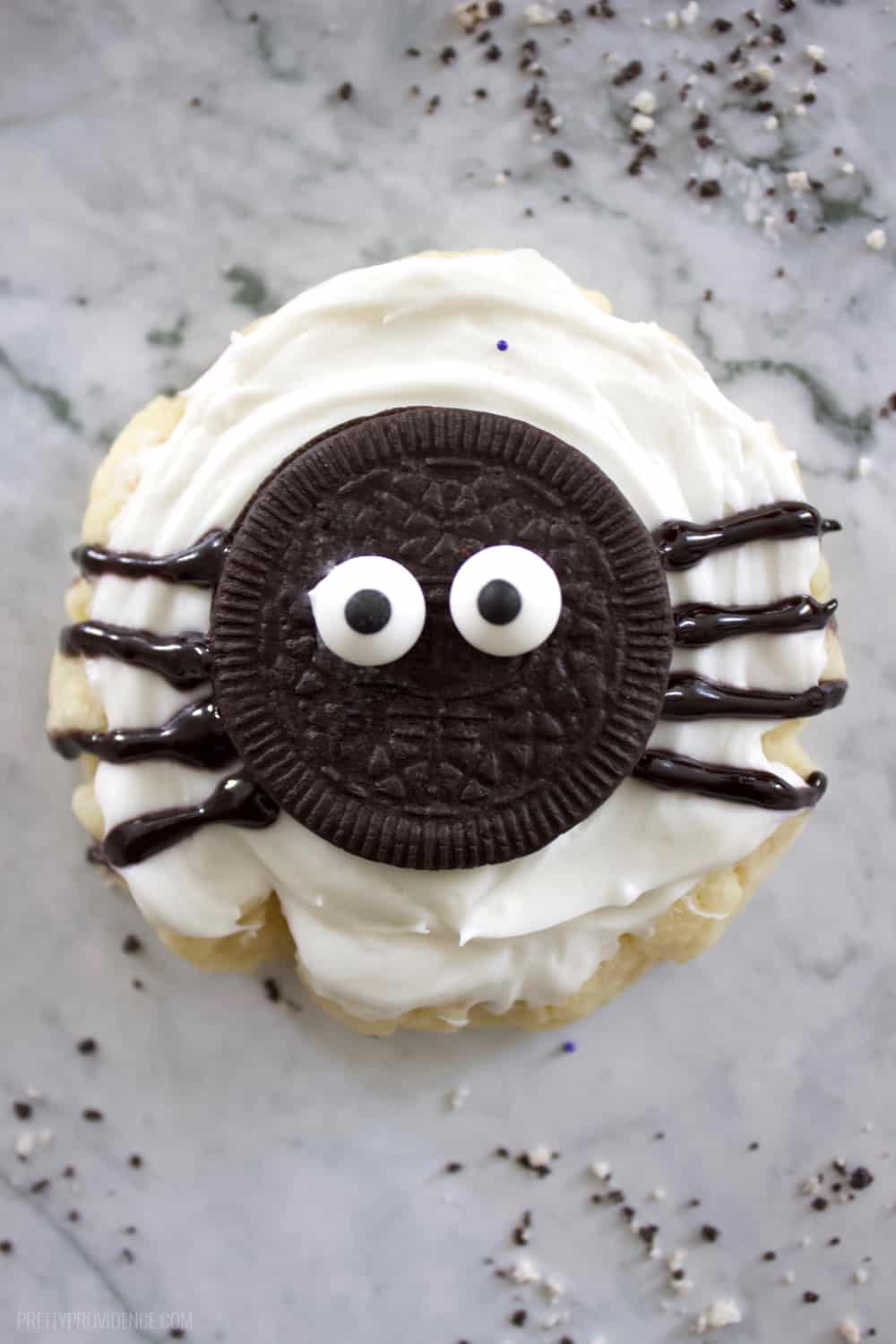 sugar cookie with an oreo spider on top sitting on a granite counter