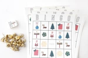 A stack of eight printable Christmas Bingo cards next to some candy.