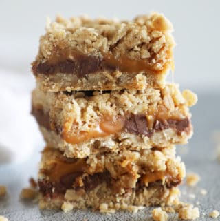 Carmelitas, layered oatmeal chocolate and caramel dessert bars, stacked on top of each other.