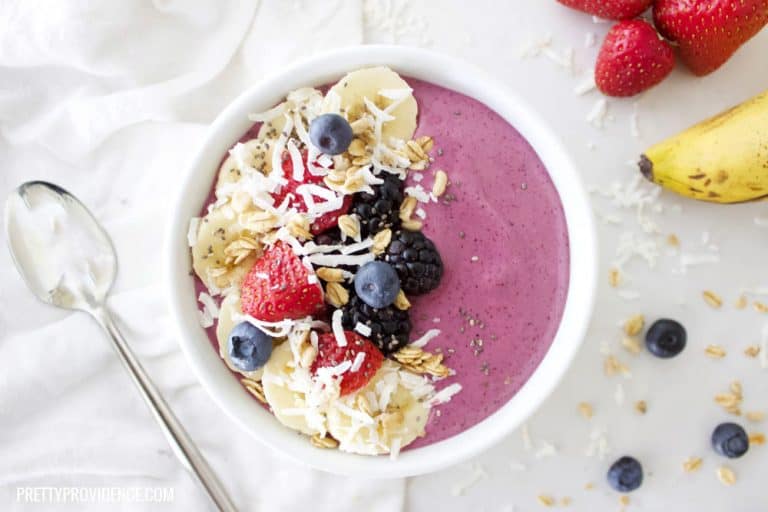 fresh berry smoothie bowl on a white counter with fresh fruit
